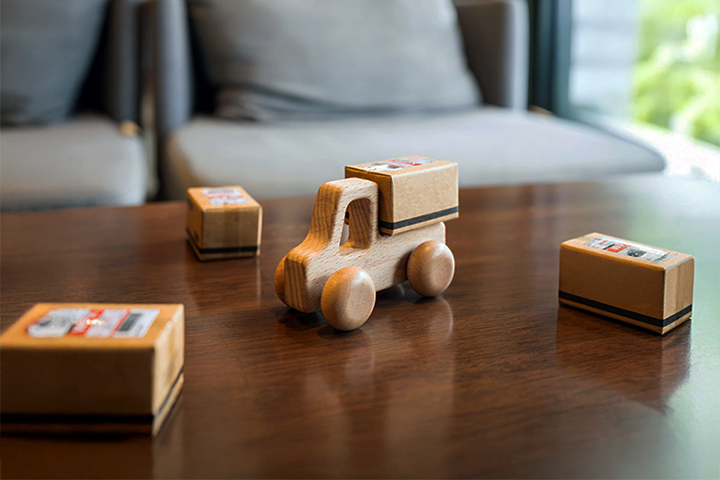 Image: Wooden toy truck with small parcels, representing parcel shipping and logistics.