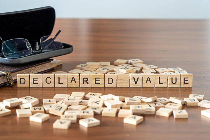 Image: Wooden letter tiles that spell out 'declared value' sitiing on a desk.