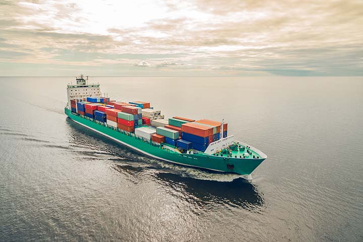 Image: Green ship sailing in the open ocean.