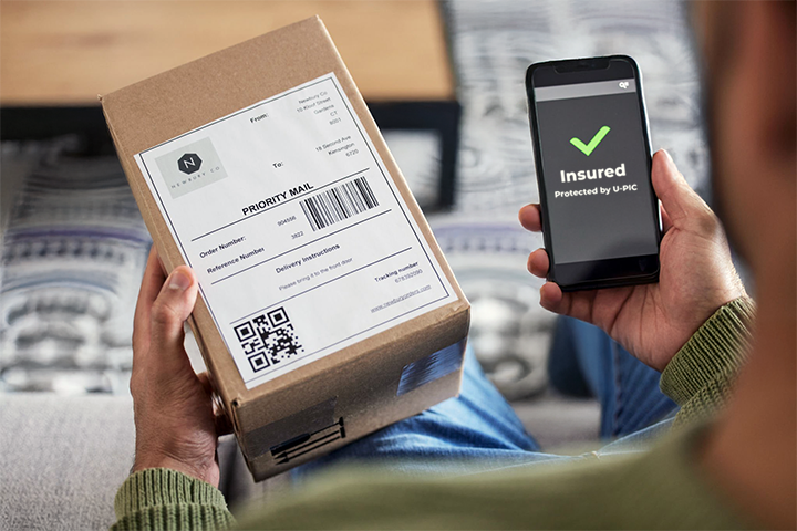 Image: Insured package with U-PIC Shipping Insurance confirmation on phone.
