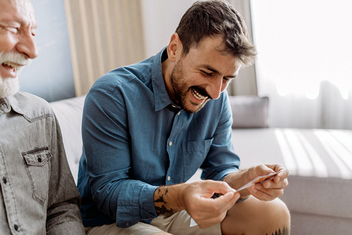 Image: A father and son looking at a collectible sports card together.