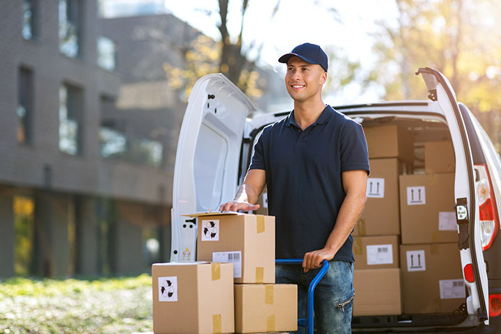 Image: Amazon delivery driver behind van.