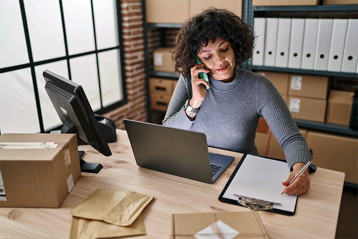 Image: Ecommerce seller on the phone taking notes.