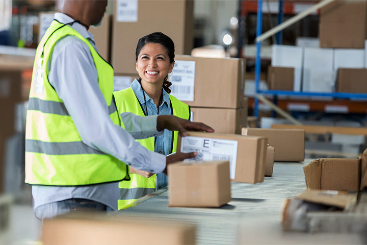 Image: Two workers fulfilling orders in a warehouse setting.