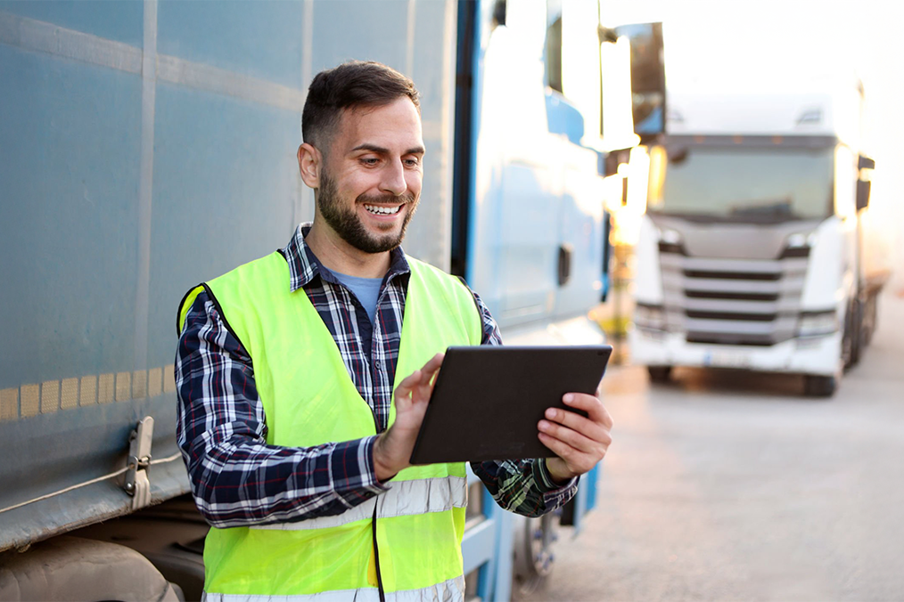 Image: A worker using a transportation management system to manage trucks.