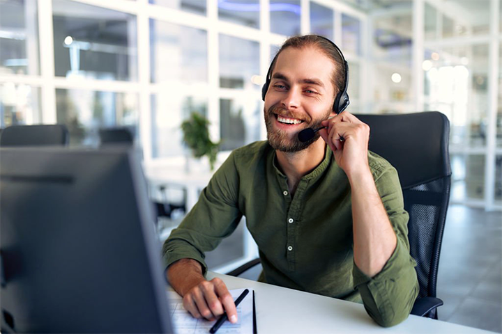 Image: A happy customer service agent on the phone with a customer.