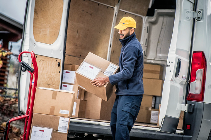 Image: A warehouse worker unpacking a shipping van.