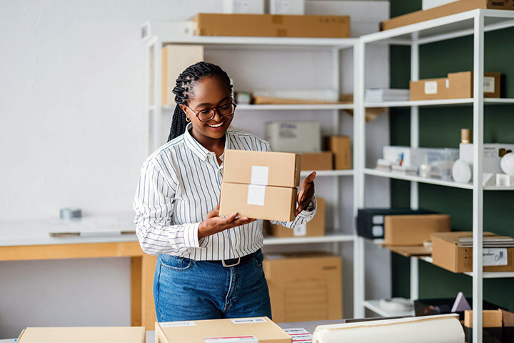 Image: A small business worker admiring packages for shipping.