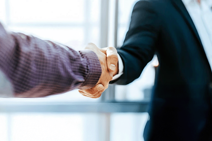 Image: Two business professionals shaking hands.